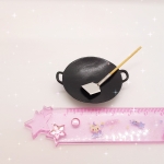 กระทะจิ๋วสีดำมีหูจับสีดำสองข้างมาพร้อมตะหลิวจิ๋วสีเงินสำหรับจัดร้านอาหารไทยจิ๋วตกแต่งห้องครัวจิ๋วให้สวยงาม